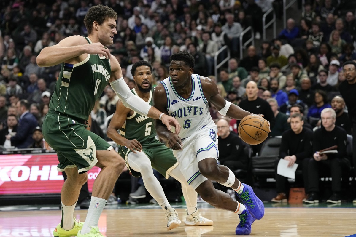 Minnesota Timberwolves guard Anthony Edwards (5) drives for the basket against Milwaukee Bucks center Brook Lopez (11)